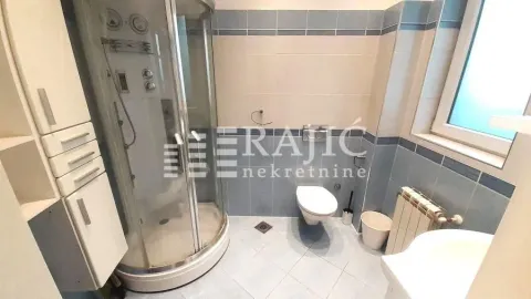 Bathroom with a shower cabin, toilet, and sink. - image 4