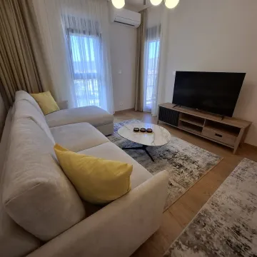 Svijetli dnevni boravak sa ugaonom garniturom, televizorom i izlazom na terasu. - image 3