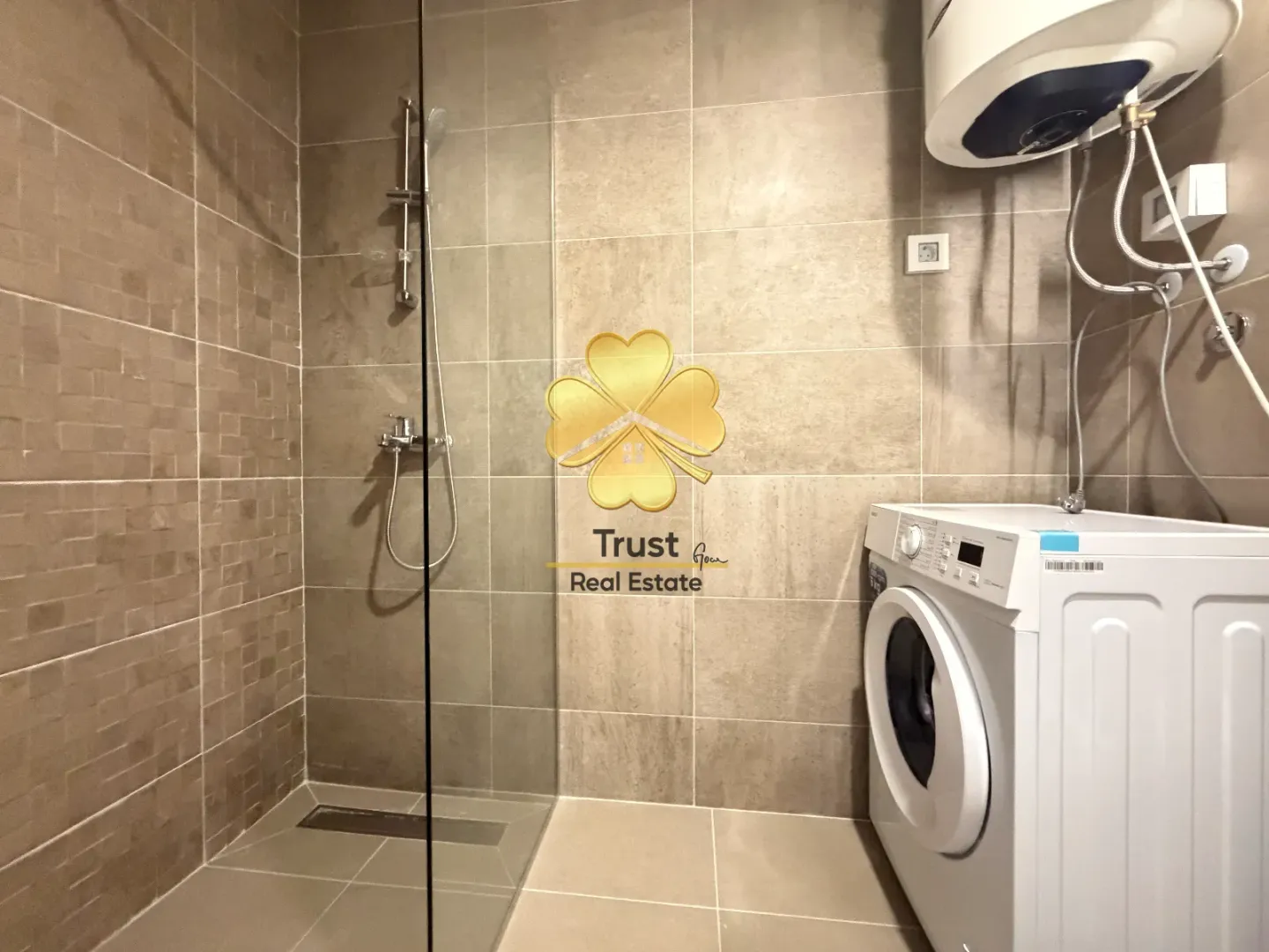 Modern bathroom with a shower cabin and a washing machine.