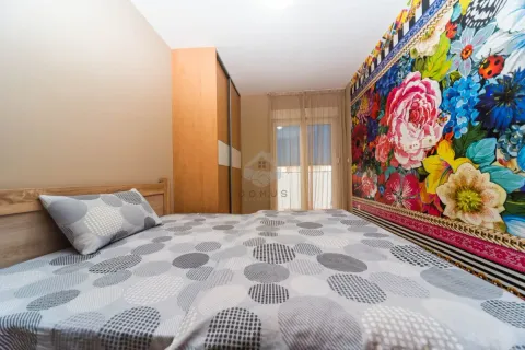 Spavaća soba sa bračnim krevetom, plakarom i zidom ukrašenim cvjetnim tapetama. - image 7
