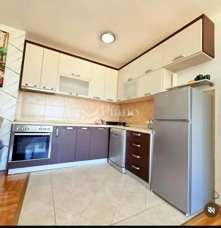 Kitchen with fitted units and a refrigerator.