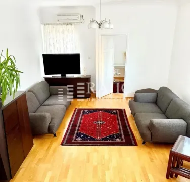Living room with a sofa set, television, and a rug. - image 4