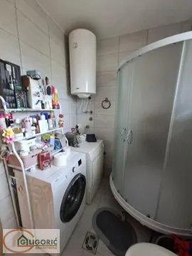 Bathroom equipped with a shower cabin, washing machine, and water heater. - image 6