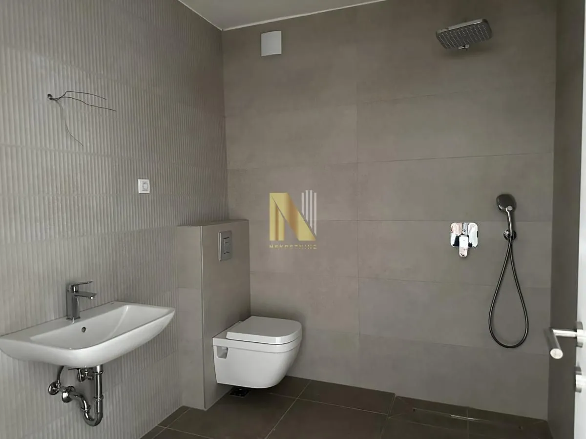 Savremeno opremljeno kupatilo sa tuš kabinom, umivaonikom i WC šoljom.