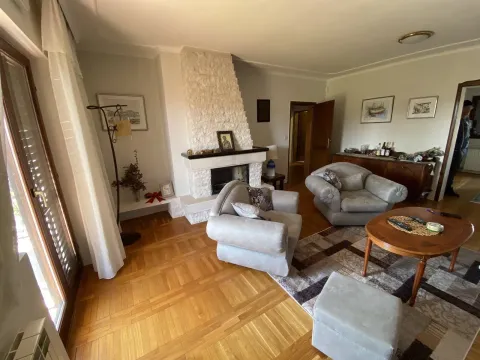 Spacious living room featuring a fireplace, comfortable armchairs, and wooden flooring. - image 10