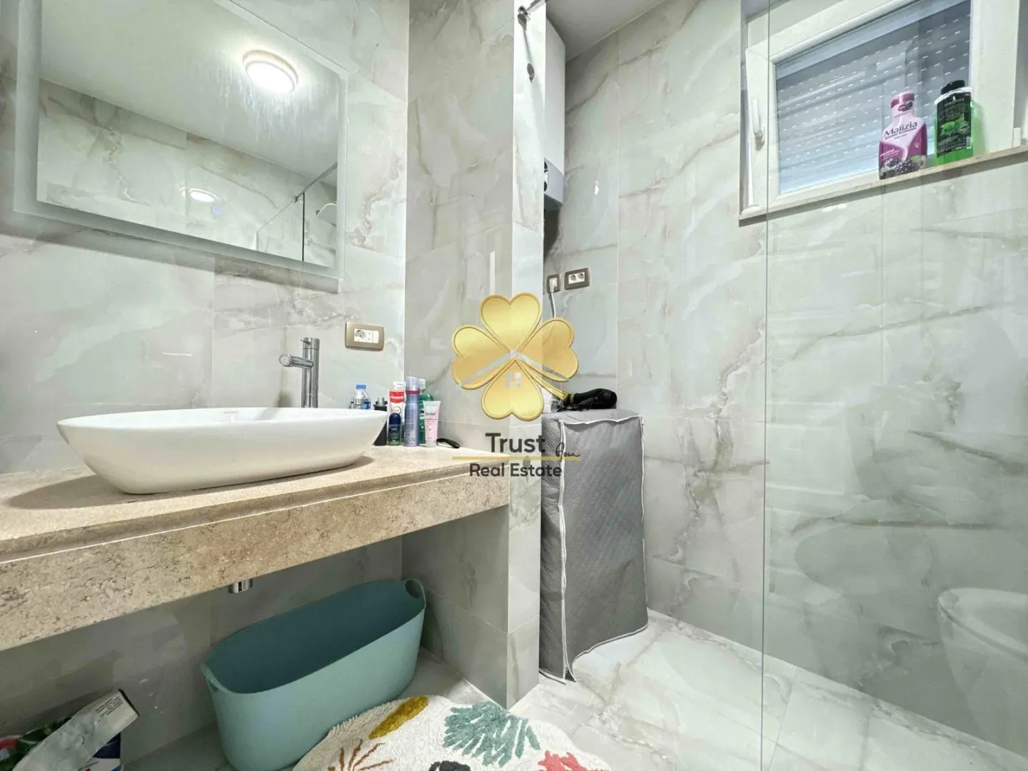 Modernly equipped bathroom with a washbasin and a walk-in shower.