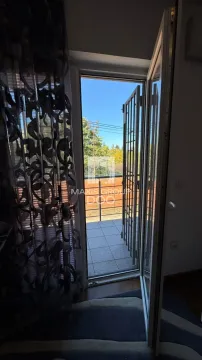 Pogled kroz otvorena balkonska vrata na terasu i zelene površine. - image 18