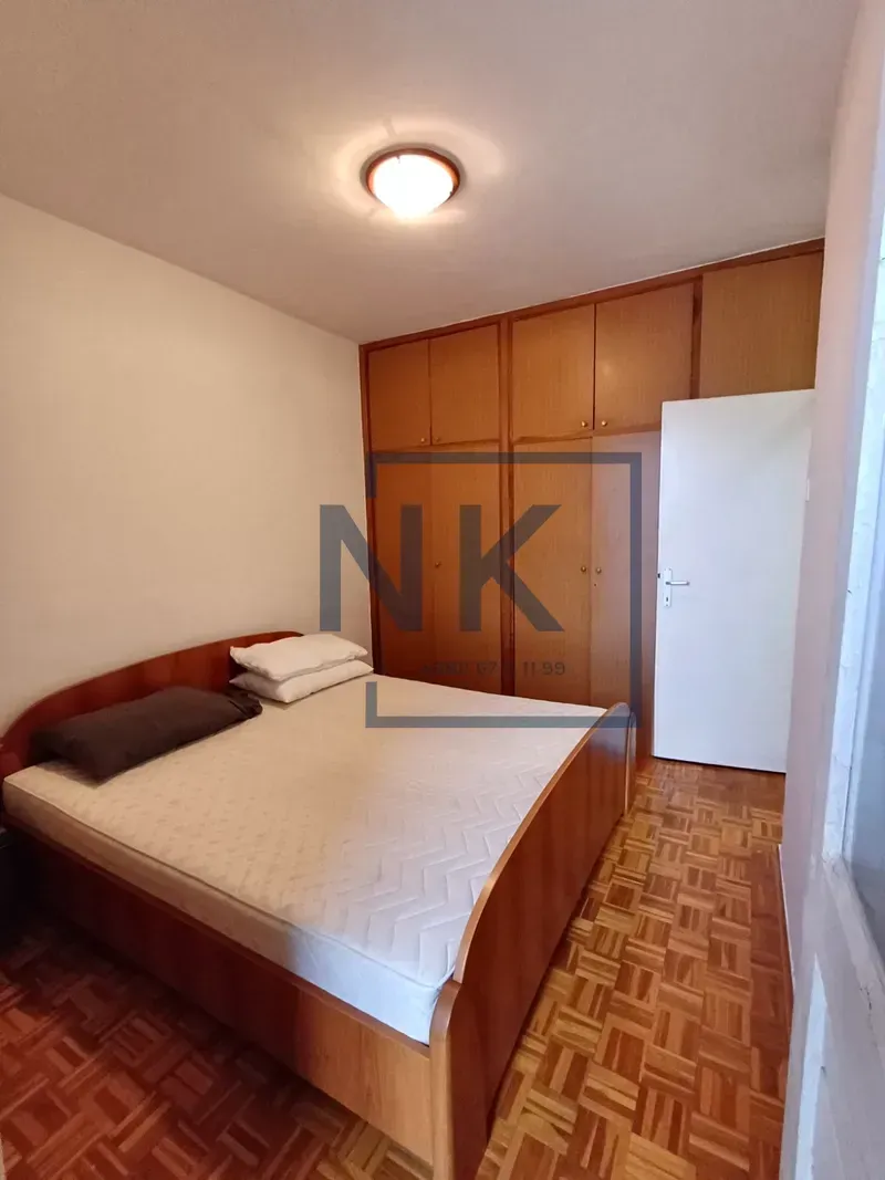 Bedroom with a double bed and wooden wardrobe.