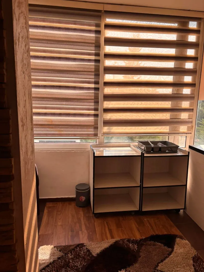 Enclosed terrace with blinds and wooden flooring.