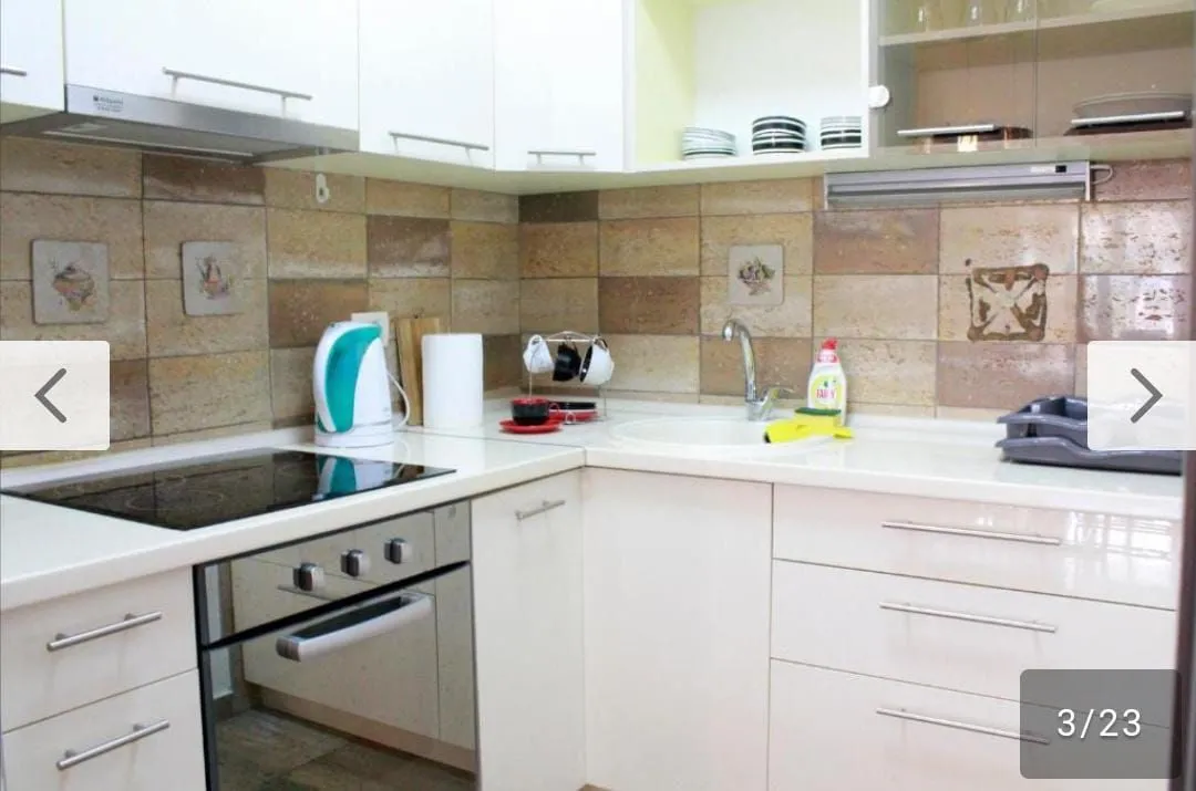 Small kitchen with white cabinets and ceramic wall tiles.
