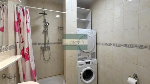 Kupatilo obloženo keramičkim pločicama sa tuš kabinom i mašinom za veš. - image 5