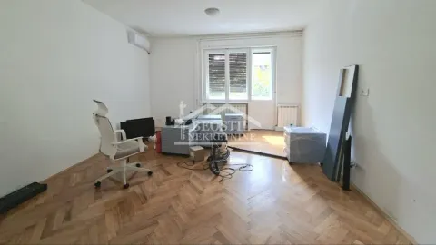 Prazna prostorija sa parketom i kancelarijskom stolicom. - image 2