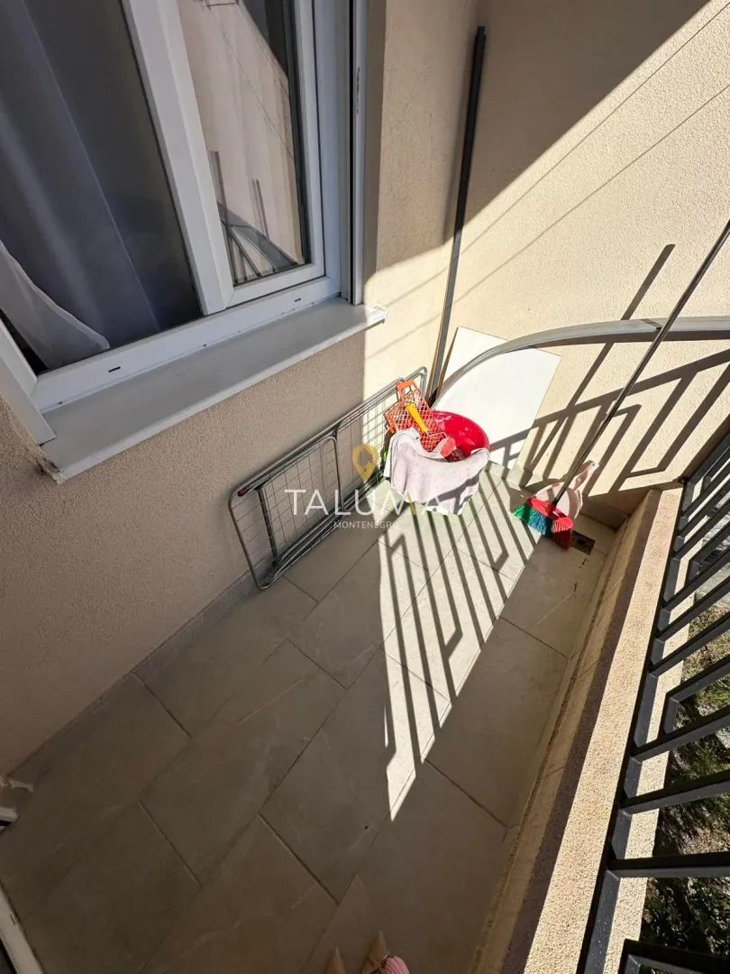 Pogled na manji popločani balkon sa priborom za čišćenje.
