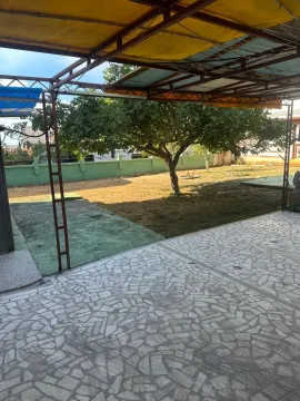 Natkrivena terasa sa pogledom na uređeno dvorište i travnjak. - image 2