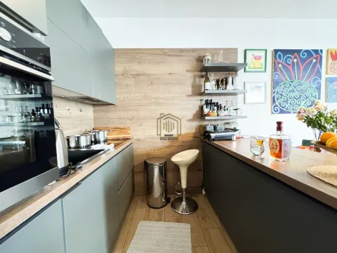 Moderna kuhinja sa sivim elementima, drvenim zidnim panelom i šankom. - image 6