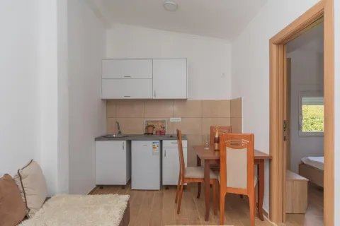 Manja kuhinja sa trpezarijskim stolom i stolicama u sklopu stana. - image 5