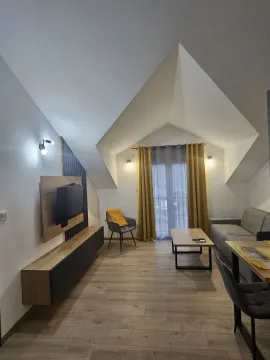 Dnevna soba sa krovnim kosinama, garniturom i TV komodom. - image 7