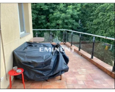 Spacious balcony with a glass railing and a view of greenery. - image 16