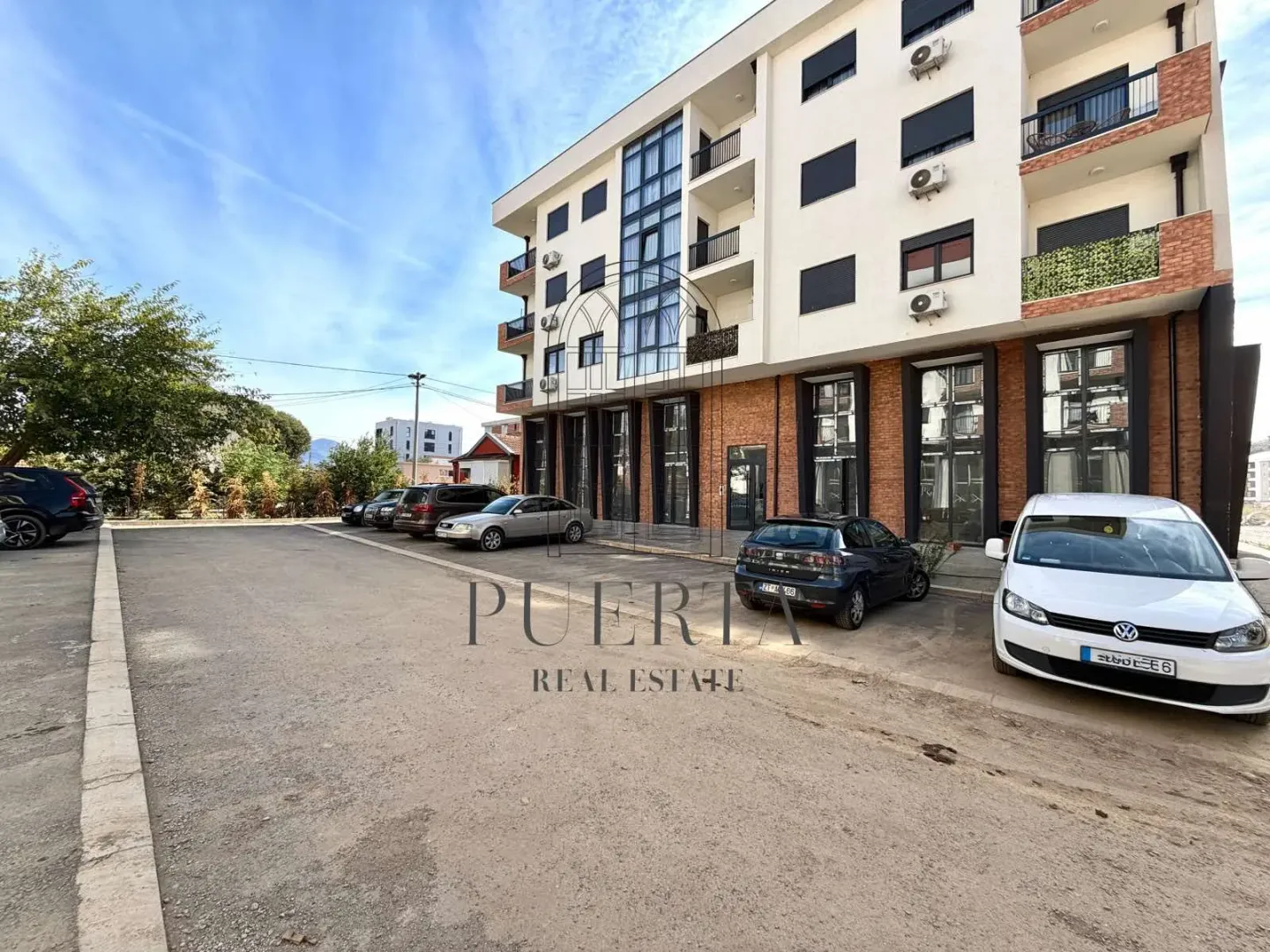 Exterior of a residential building with parking and entrance.