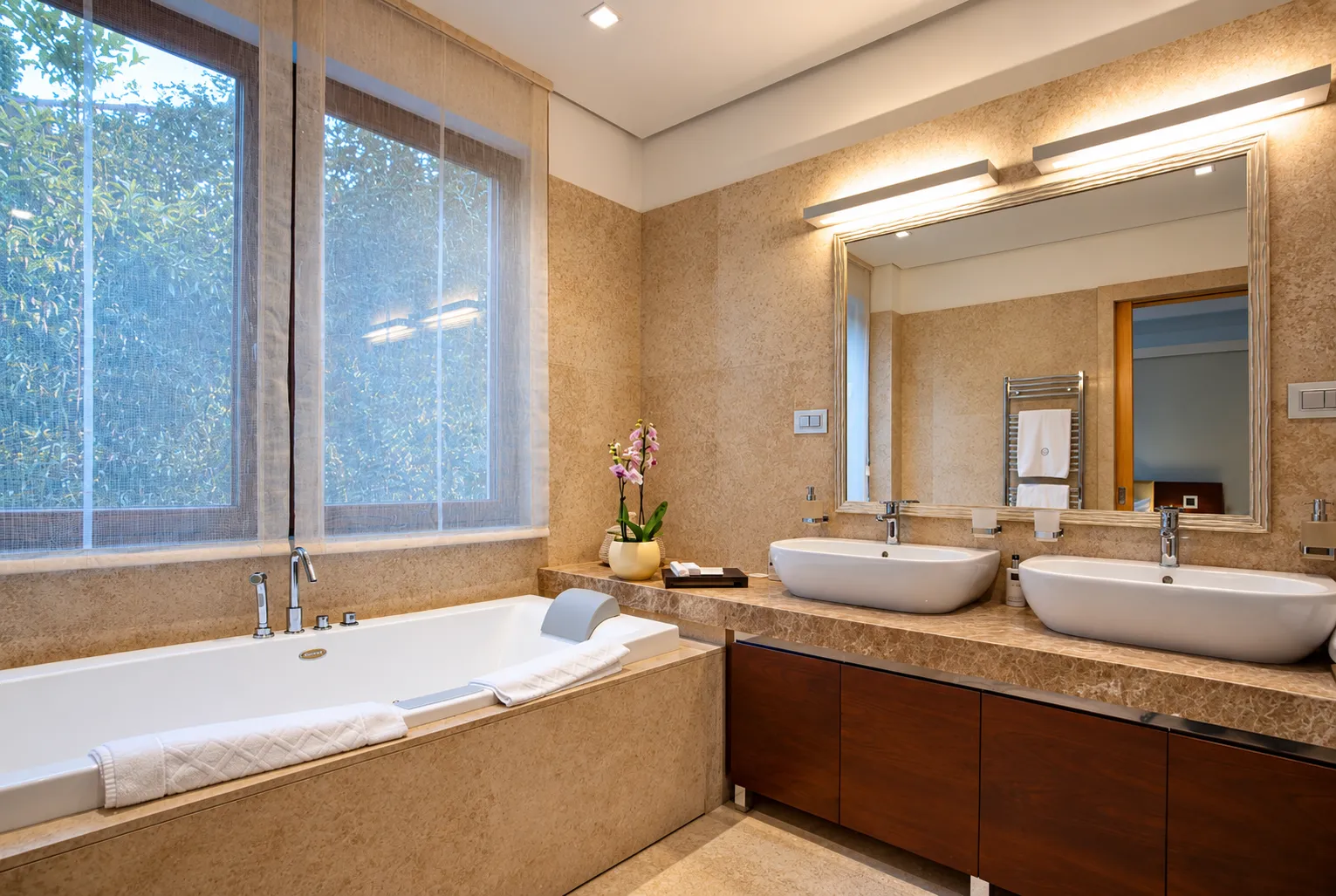 Spacious bathroom with a bathtub, large window, and double vanity.