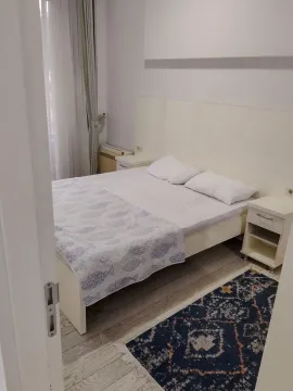 Spavaća soba sa bračnim krevetom, noćnim stočićima i prozorom sa zavjesama. - image 6