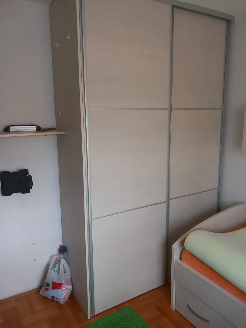 Veliki plakar sa kliznim vratima pored kreveta u spavaćoj sobi.