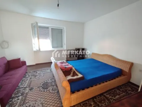 Nameštena spavaća soba sa bračnim krevetom i ljubičastom sofa garniturom. - image 10