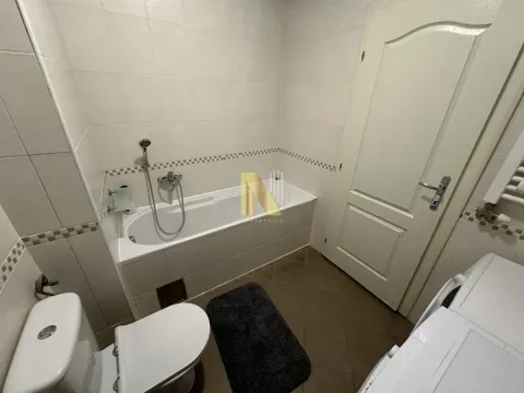 Kupatilo opremljeno kadom, wc šoljom i pločicama na zidovima. - image 7