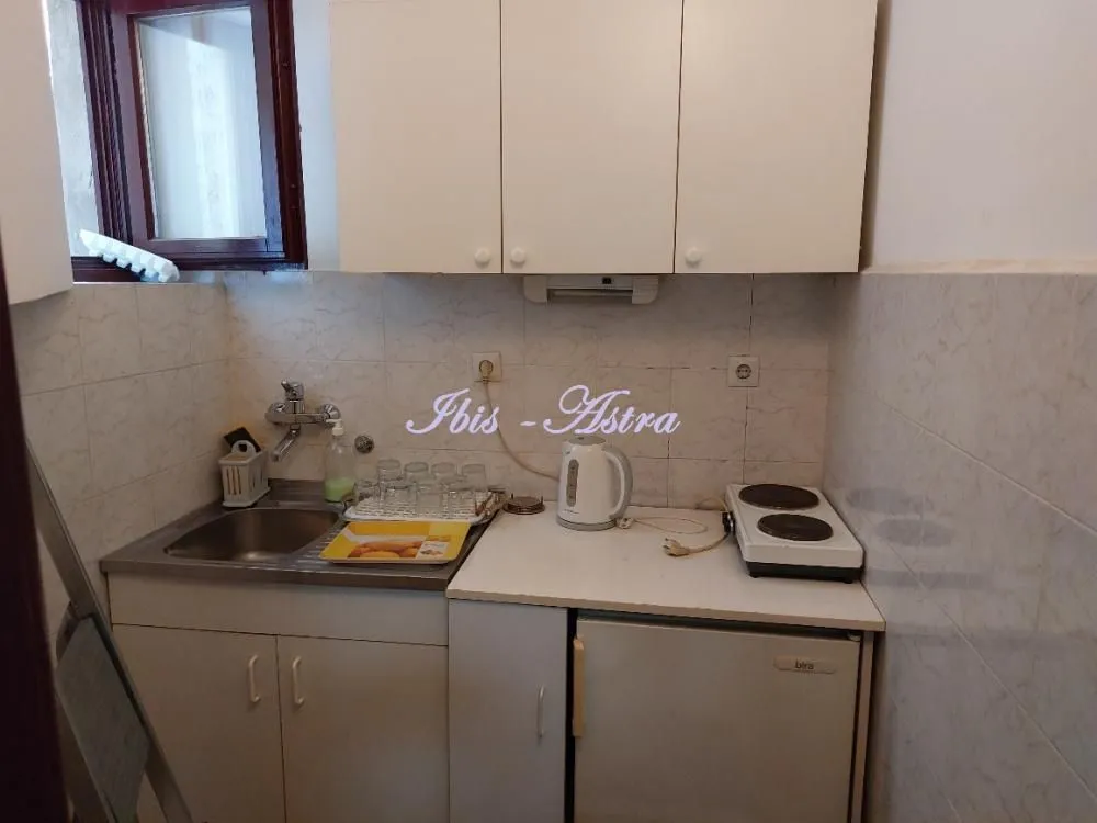 Small kitchen with a sink, refrigerator, and cabinetry.