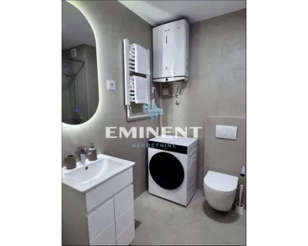 Modern bathroom equipped with sanitary ware, a shower cabin, and a washing machine. - image 9