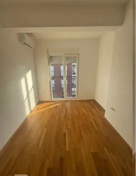 Empty room with parquet flooring and an air conditioner. - image 3