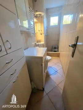 Manje kupatilo sa veš mašinom, tuš kabinom i belim ormarićem. - image 10