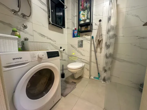 Manje kupatilo sa veš mašinom, tuš kabinom i bijelim sanitarijama. - image 8