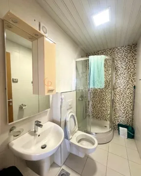 Kupatilo opremljeno umivaonikom, WC šoljom i tuš kabinom. - image 8