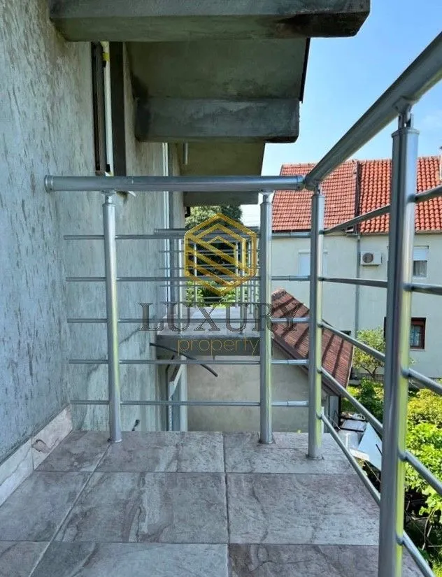 Pogled sa popločanog balkona sa metalnom ogradom.