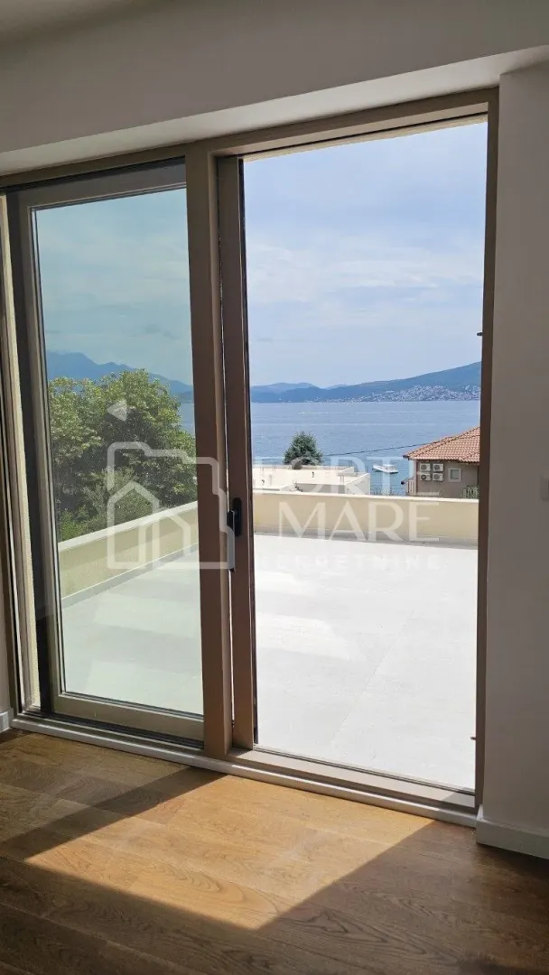 Pogled na more kroz veliku balkonsku vrata sa terasom.