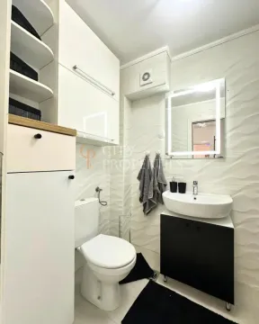 Savremeno opremljeno kupatilo sa umivaonikom, WC šoljom i belim visećim elementima. - image 9