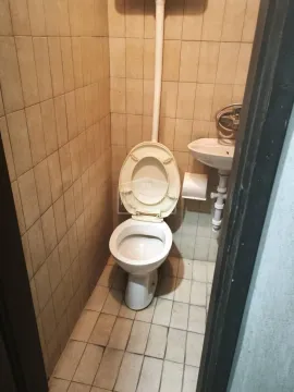 Small bathroom with a toilet and a sink, tiled with ceramic tiles. - image 7
