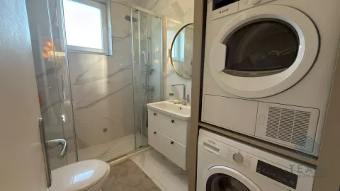 Moderno opremljeno kupatilo sa tuš kabinom i ugradnom mašinom za pranje i sušenje veša. - image 6