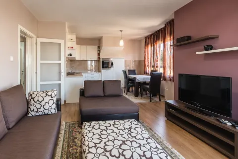 Dnevna soba sa garniturom, televizorom i trpezarijom u pozadini. - image 3