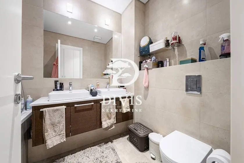 Moderno opremljeno kupatilo sa dva umivaonika, ogledalom i WC šoljom.
