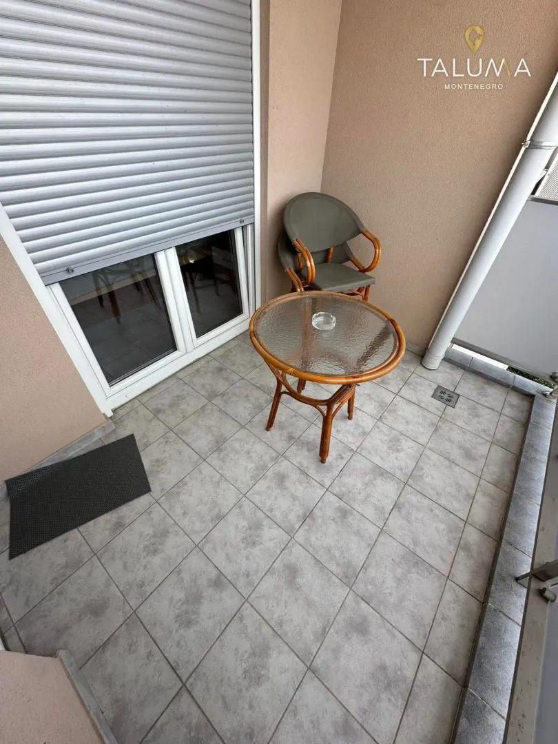 Manji natkriveni balkon sa popločanim podom i garniturom za sjedenje.