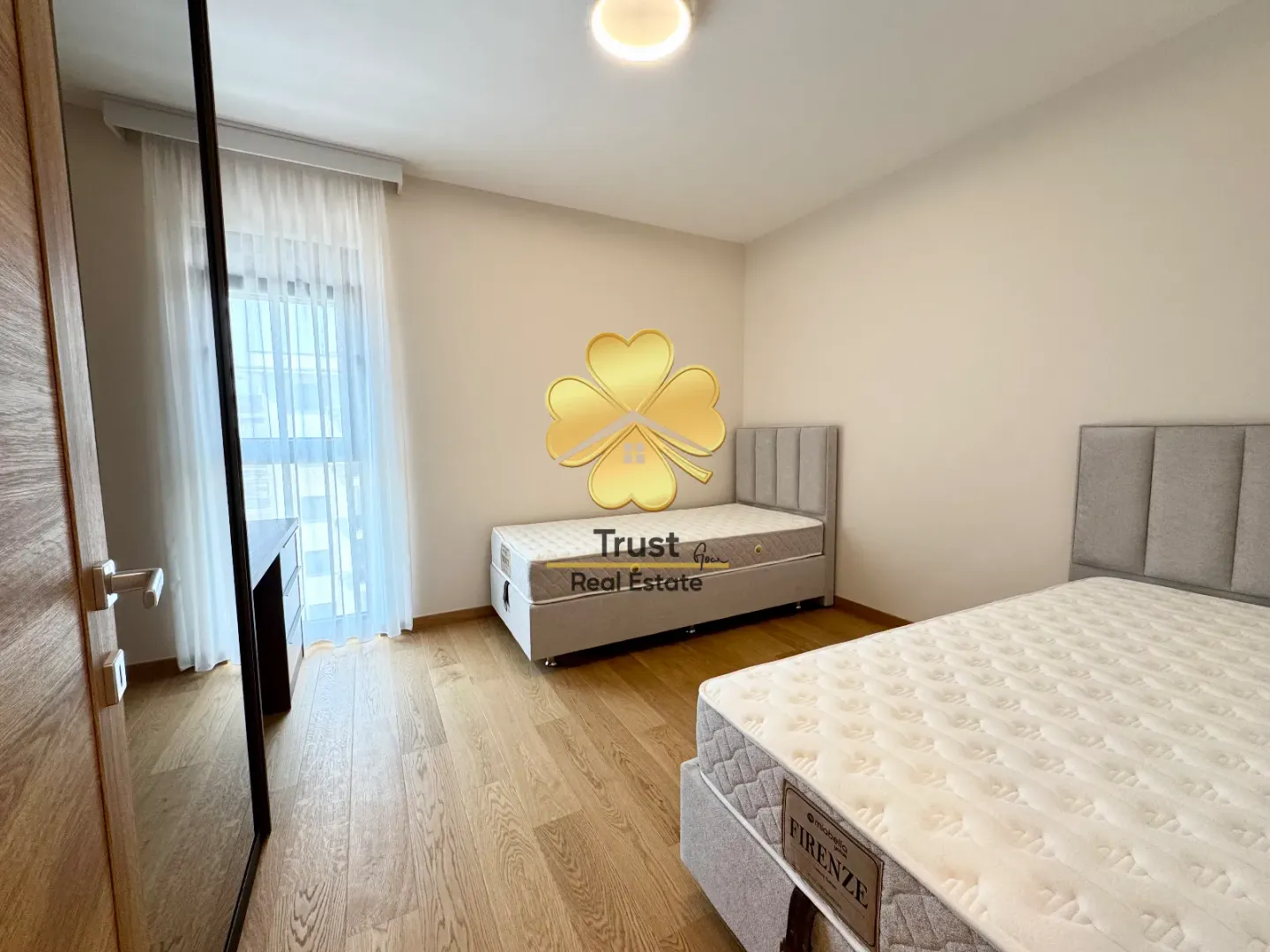Modern bedroom with two single beds and a wardrobe.
