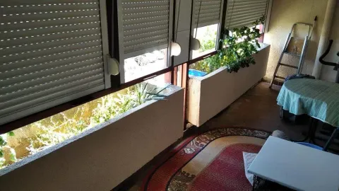 Zastakljeni balkon sa roletnama i žardinijerama za cvijeće. - image 24