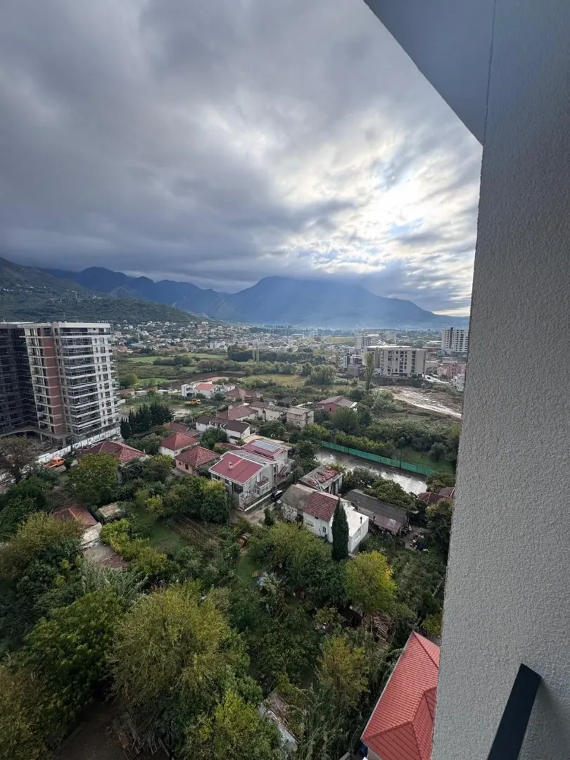 Pogled sa terase na grad, naselje i planine u pozadini.
