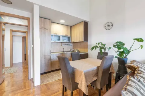 Small kitchen with a dining table and chairs within the apartment. - image 3