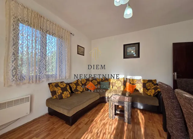 Dnevni boravak sa garniturom i trpezarijskim stolom.