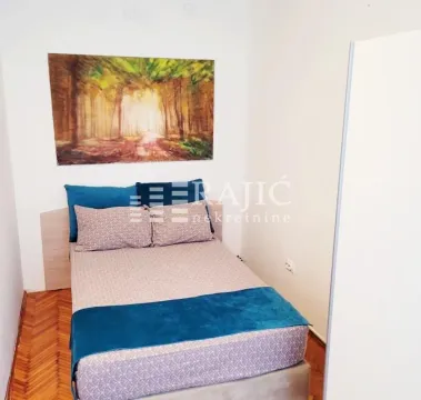 Smaller bedroom with a double bed and parquet flooring. - image 5