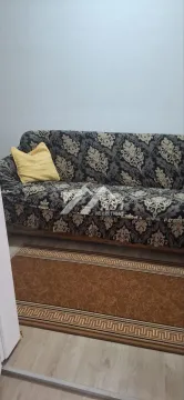Kauč sa dezeniranim prekrivačem i žutim jastukom u dnevnoj sobi. - image 11