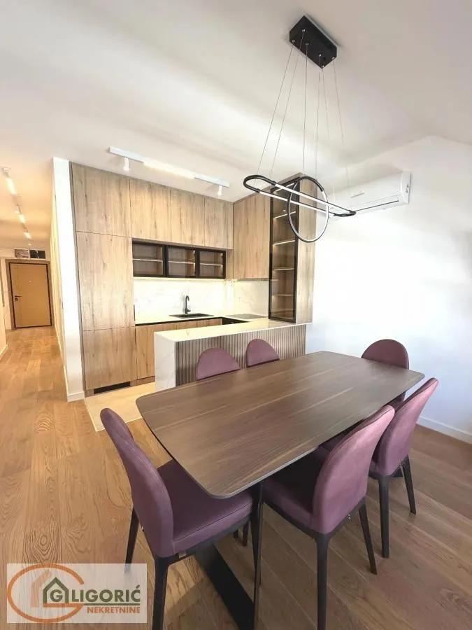 Modern kitchen with dining area and wooden furniture.